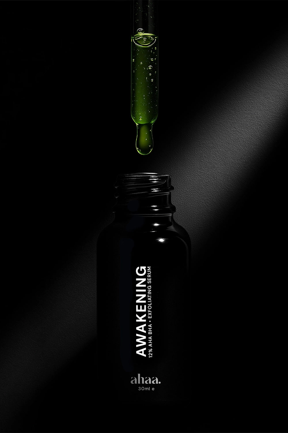 AHA BHA exfoliating serum bottle on black background